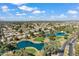 Scenic aerial shot capturing the community's beautiful ponds and golf course nestled among many homes and mature trees at 17077 N Zuni Trl, Surprise, AZ 85374