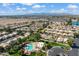 Aerial view of a well-planned community with homes, a pool area, green spaces, and mountain views at 17077 N Zuni Trl, Surprise, AZ 85374