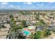 Community aerial view showcasing homes, community pool with surrounding green spaces and distant mountains at 17077 N Zuni Trl, Surprise, AZ 85374