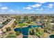 Aerial view of a lush golf course community with scenic water features, palm trees, and mountain views at 17077 N Zuni Trl, Surprise, AZ 85374