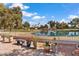 Tranquil backyard featuring a covered patio, lush landscaping, and a calming view of a serene lake at 17077 N Zuni Trl, Surprise, AZ 85374