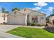 Charming single-story home featuring well-maintained landscaping, a two-car garage, and a welcoming facade at 17077 N Zuni Trl, Surprise, AZ 85374