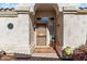 Inviting front entrance with a decorative rug, potted plants, and a stylish screen door at 17077 N Zuni Trl, Surprise, AZ 85374