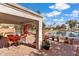 Charming covered patio with brick pavers, blooming flowers, and scenic lake views for relaxing outdoors at 17077 N Zuni Trl, Surprise, AZ 85374