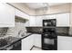 Well-equipped kitchen with white cabinets, black appliances, and eye-catching backsplash at 1736 E Coronado Rd, Phoenix, AZ 85006