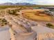 Aerial view of sports area with dirt bike mounds and a baseball field surrounded by desert landscape and distant mountains at 17496 W Summit Dr, Goodyear, AZ 85338