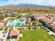 Expansive aerial view of the community pool, clubhouse, and desert landscape with mountain views in the distance at 17496 W Summit Dr, Goodyear, AZ 85338