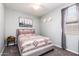 Bright bedroom featuring neutral walls, a patterned bedspread, and two decorative cowboy hats at 17496 W Summit Dr, Goodyear, AZ 85338