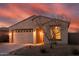 A home's exterior in warm evening light showing the garage, walkway, and desert landscaping at 17496 W Summit Dr, Goodyear, AZ 85338