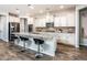 Modern kitchen with white cabinetry, granite countertops, stainless steel appliances, and a breakfast bar with seating at 17496 W Summit Dr, Goodyear, AZ 85338