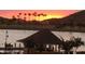 Scenic pond with gazebo, palm trees, and a vibrant sunset backdrop at 17496 W Summit Dr, Goodyear, AZ 85338