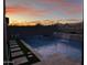 Backyard pool area with a modern design, featuring a waterfall feature and serene landscaping at 17496 W Summit Dr, Goodyear, AZ 85338