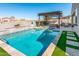 Sparkling pool with sun shelf, pergola, and manicured landscaping at 17496 W Summit Dr, Goodyear, AZ 85338