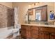 Well-lit bathroom with a double vanity, granite counters and tile flooring at 18332 W Latham St, Goodyear, AZ 85338