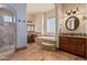 Charming bathroom featuring a large bathtub, walk-in shower, and vanity at 18332 W Latham St, Goodyear, AZ 85338