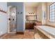 Bright bathroom features a large soaking tub and walk-in shower at 18332 W Latham St, Goodyear, AZ 85338