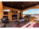 Cozy interior of the gazebo features a built-in grill, fireplace and comfortable seating area at 18332 W Latham St, Goodyear, AZ 85338