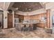 Gourmet kitchen boasts an island with stone accents, granite countertops, stainless steel appliances, and custom cabinetry at 18332 W Latham St, Goodyear, AZ 85338