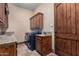 Functional laundry room with granite countertops and a modern washer and dryer at 18332 W Latham St, Goodyear, AZ 85338