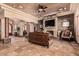 Spacious living room features stone fireplace, tile flooring, a ceiling fan and refined decor at 18332 W Latham St, Goodyear, AZ 85338