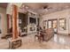 Cozy living room boasts a stone fireplace, wood beamed columns and tiled floors at 18332 W Latham St, Goodyear, AZ 85338