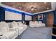 Home theater featuring white recliners, a textured ceiling, and elegant curtains at 18332 W Latham St, Goodyear, AZ 85338