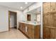 Bathroom with a double sink vanity, decorative tile countertop, and wooden storage at 1938 E Myrna Ln, Tempe, AZ 85284