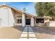 Inviting single-story home featuring a stucco facade, desert landscaping and dark trim on the front door and windows at 1938 E Myrna Ln, Tempe, AZ 85284