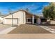 Inviting single-story home featuring a stucco facade, two car garage, a basketball hoop and desert landscaping at 1938 E Myrna Ln, Tempe, AZ 85284