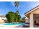 Backyard pool with palm trees, hedges, and flowers, creating a perfect outdoor oasis for relaxation at 1938 E Myrna Ln, Tempe, AZ 85284