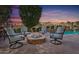 A patio and outdoor seating area with a stone fire pit and a pool in the background at 22206 N 36Th Way, Phoenix, AZ 85050