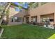 A sprawling artificial turf lawn complements the home's tan stucco exterior and backyard patio area at 22206 N 36Th Way, Phoenix, AZ 85050