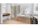 Neutral bathroom featuring a walk-in shower, soaking tub, dual vanities, and travertine tile at 22206 N 36Th Way, Phoenix, AZ 85050