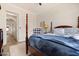 Cozy bedroom with a four-poster bed, plush blue blanket, and decorative chair near an arched doorway at 22206 N 36Th Way, Phoenix, AZ 85050