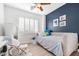 Comfortable bedroom with a cozy daybed, a striking blue accent wall, and natural light from shuttered windows at 22206 N 36Th Way, Phoenix, AZ 85050