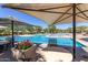 Community pool and seating area with shade umbrellas, flowers, and lush landscaping for relaxation at 22206 N 36Th Way, Phoenix, AZ 85050