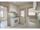 Efficient kitchen with white cabinets and appliances, tiled flooring, and natural light from a window at 2237 E Windsor Ave, Phoenix, AZ 85006