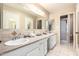 Well-lit bathroom with a double sink vanity, large mirror, and white cabinets at 25236 S Lakeway Dr, Sun Lakes, AZ 85248