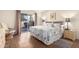 Sunlit bedroom with a patterned comforter, wood-look floors, and a sliding glass door to the outside patio at 25236 S Lakeway Dr, Sun Lakes, AZ 85248