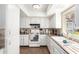 Well-lit kitchen with white cabinets, tile backsplash, and a window providing natural light at 25236 S Lakeway Dr, Sun Lakes, AZ 85248