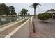 Backyard gravel area featuring a pond view, palm tree, and mature shrubbery near a privacy wall at 25236 S Lakeway Dr, Sun Lakes, AZ 85248