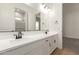 Bright bathroom featuring double sinks with matte black faucets, white cabinetry, and a large mirror at 25372 N 158Th Ct, Surprise, AZ 85387