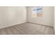 Carpeted bedroom with white walls, a large window, base trim, and electrical outlets at 25372 N 158Th Ct, Surprise, AZ 85387