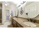 Bathroom featuring dual sinks, granite countertops, and decorative mirrors at 2558 E Inglewood St, Mesa, AZ 85213