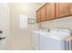 Bright laundry room with overhead cabinets, washer and dryer at 2662 S Springwood Blvd # 461, Mesa, AZ 85209