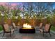 Cozy backyard seating around a modern fire pit, framed by lush greenery and a stone paver patio at 2843 E Los Gatos Dr, Phoenix, AZ 85050