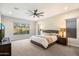 Inviting main bedroom with a king-size bed, nightstands, ceiling fan, and large windows with natural light at 2843 E Los Gatos Dr, Phoenix, AZ 85050