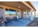 Covered back patio area with outdoor seating and views of the natural desert landscape at 34515 N 142Nd St, Scottsdale, AZ 85262