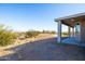 The backyard features a covered patio and desert landscape with bushes and mountain in the distance at 34515 N 142Nd St, Scottsdale, AZ 85262