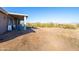 Expansive backyard featuring a covered patio and natural desert landscaping, perfect for outdoor living at 34515 N 142Nd St, Scottsdale, AZ 85262